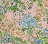 Floral fabric with large blue and cream peony-like flowers, green leaves, and small white blossoms on a blush pink background.
