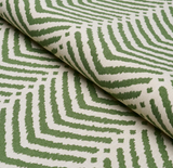 Close-up of folded fabric with a green geometric zigzag pattern on cream background, showcasing textured lines and subtle diamond shapes.