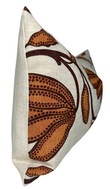 Rectangular beige pillow with a bold ochre and dark brown floral pattern featuring large stylized blossoms and dotted details, shown from a side angle.