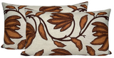 Three rectangular pillows with beige background and large ochre floral patterns outlined in dark brown dots and stems, arranged side by side.