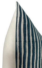 Corner of a pillow cover with alternating thick and thin Indian teal stripes against an off-white background, showing texture and fine stitching detail.