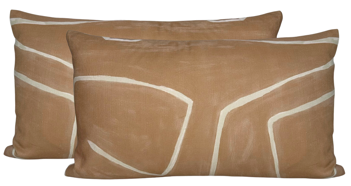 Two rectangular pillows with salmon cream fabric featuring irregular white line patterns forming abstract shapes.