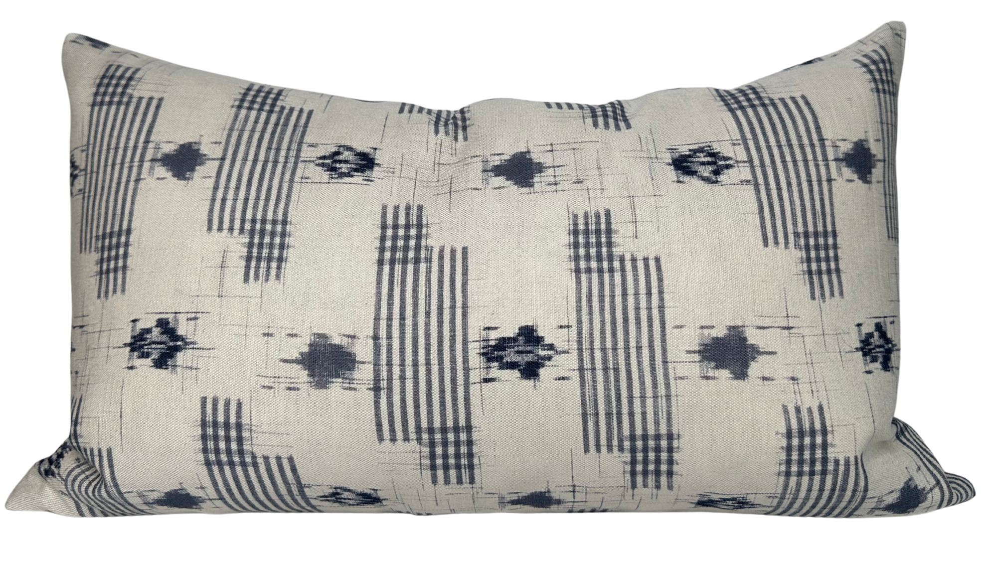 Yamato Pillow Cover in Blue laying on a sofa showing its blue printed front and ivory linen back