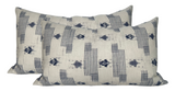 Two rectangular pillows with a cream background featuring vertical dark blue striped and geometric patterns.