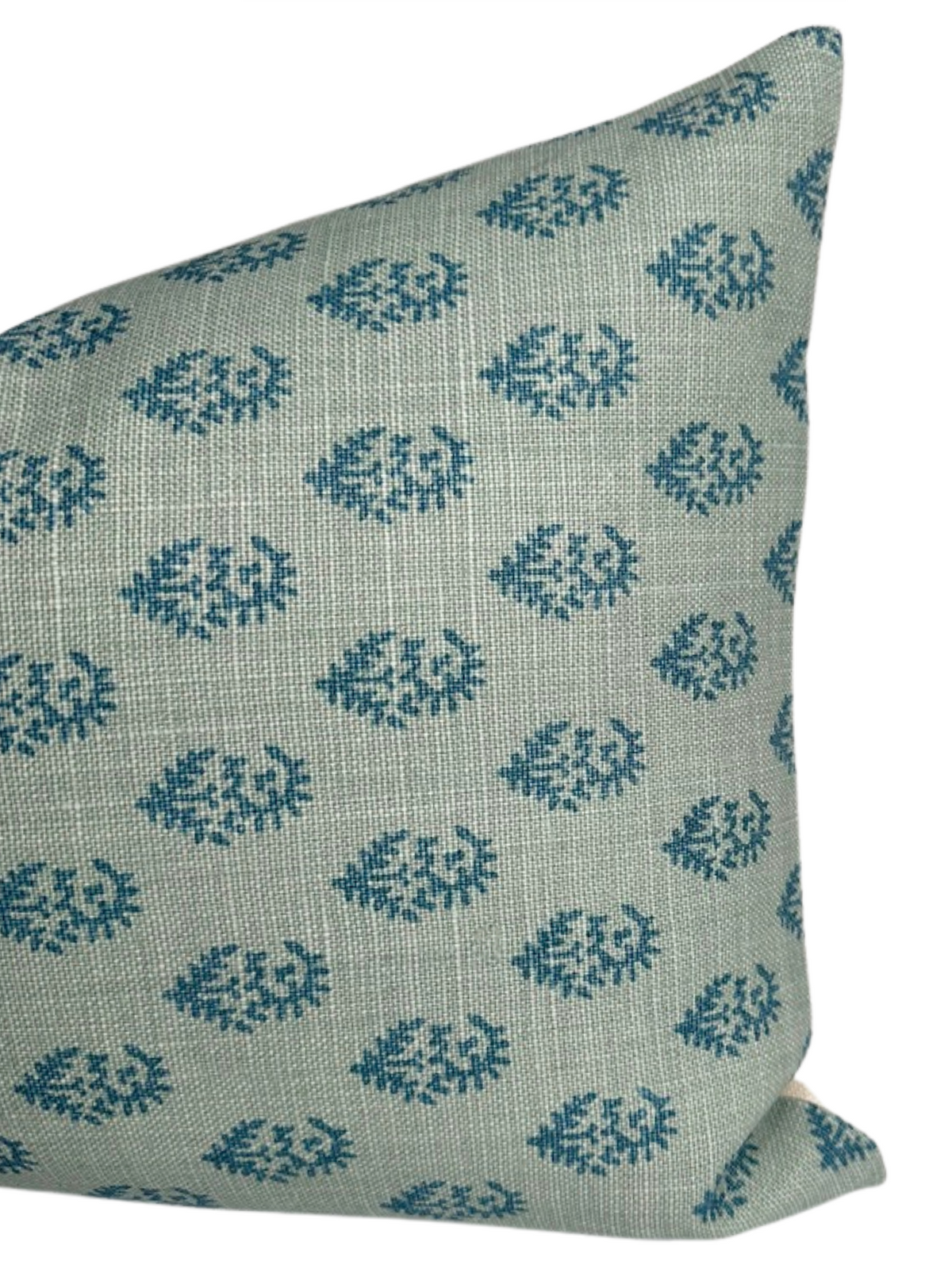 Close-up of a fabric pillow cover with a repeating small blue paisley pattern on a light bluish-gray textured background.