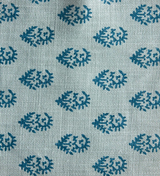 Light blue pillow fabric with evenly spaced small dark blue paisley motifs in a repeating pattern.