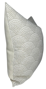 Square pillow cover in natural color featuring a scalloped pattern of small dots creating arches, shown from a side angle highlighting its texture and shape.