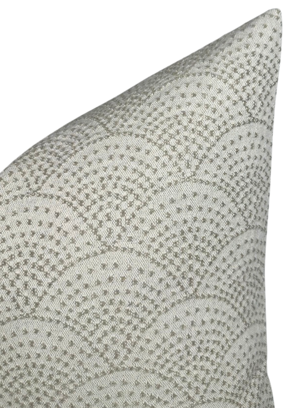 Corner of a woven pillow cover displaying a scalloped pattern in natural beige and light gray tones with textured fabric.