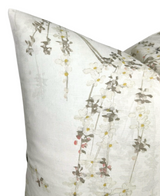 Beige pillow cover with delicate gray and yellow weeping blossom floral patterns cascading diagonally across the fabric.