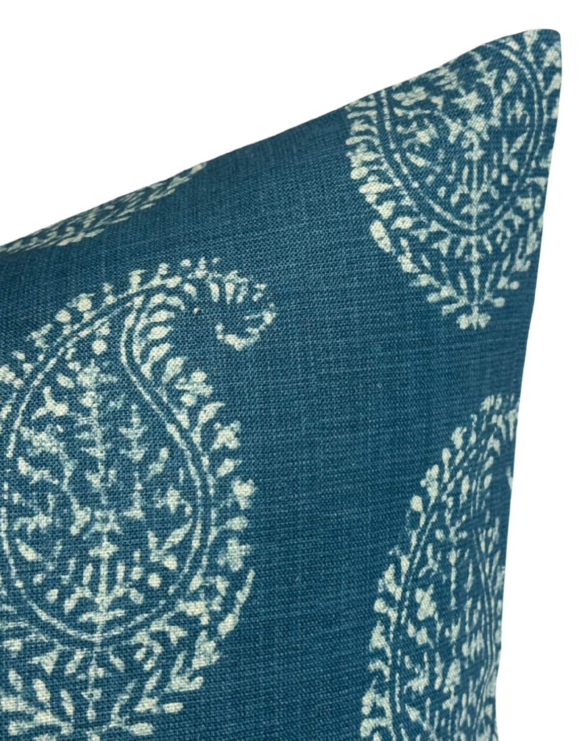 Close-up of an indigo blue pillow cover featuring a white paisley floral pattern with detailed circular and leaf motifs.