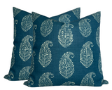 Two square pillows with an indigo blue background featuring a repeating white Kashmiri paisley floral pattern, made from textured fabric.