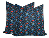 Three indigo pillow covers with a repeating twine pattern in blue and bold red accents on a dark background.