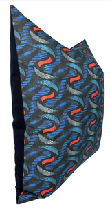 Square pillow cover with a twisting wave pattern in indigo blue, gray, and red on the front, and solid dark navy fabric on the back.