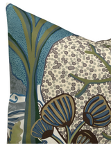 Corner of a pillow cover featuring an abstract botanical pattern with large stylized blue and olive-green leaves against a beige background with scattered gray dots.