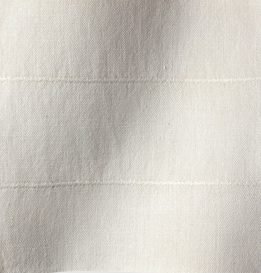 Close-up of sandstone-colored fabric with a subtle woven texture and two faint horizontal stitched lines evenly spaced apart.