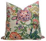 Square beige fabric pillow cover with colorful floral design featuring large pink, red, orange, and green flowers and leaves in a garden style.
