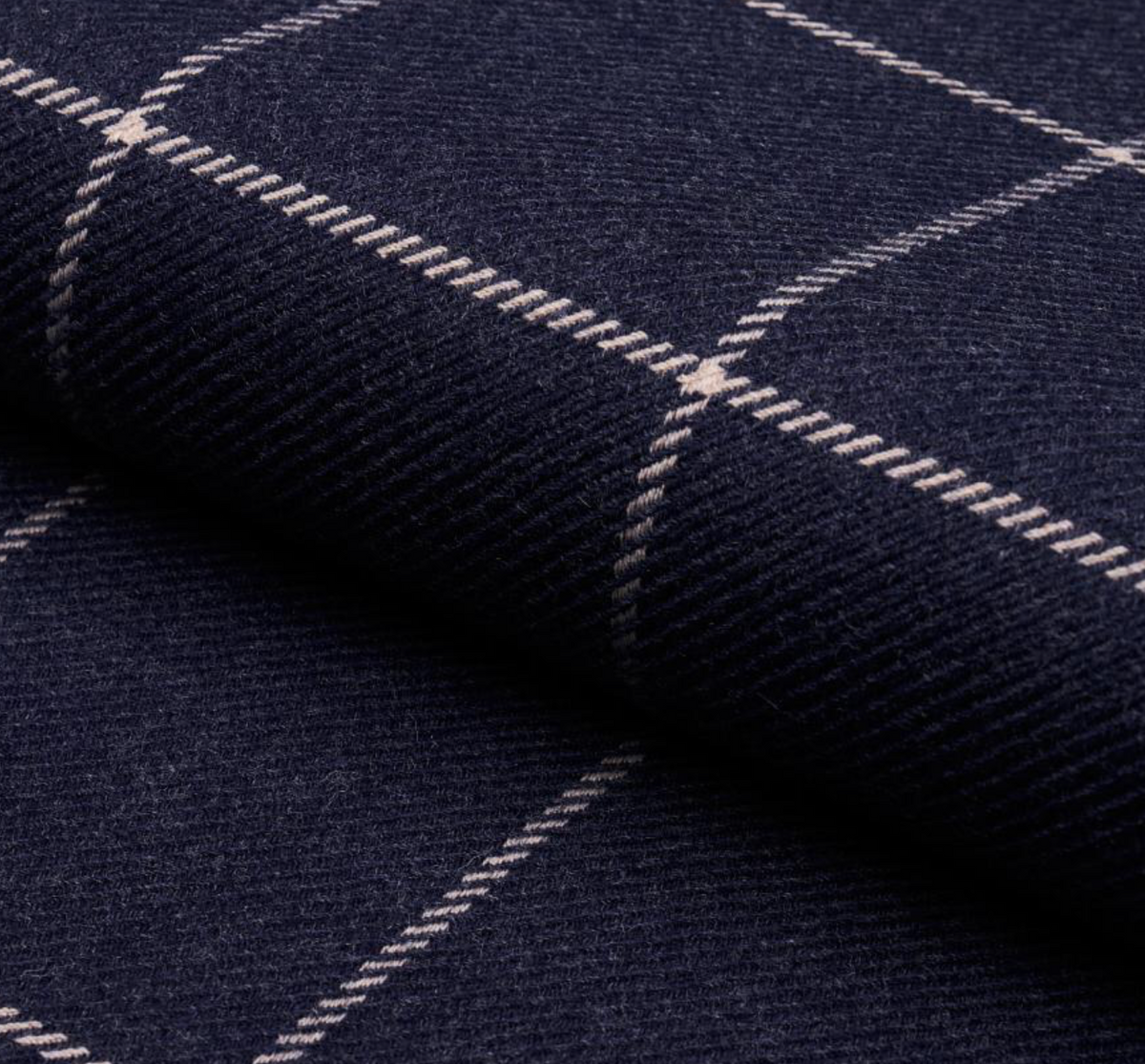 Close-up of navy blue wool fabric with a light beige grid pattern, showing texture and a soft fold.