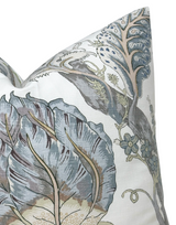 Close-up of a pillow cover featuring large stylized blue and gray floral motifs with intricate leaf and vine details on a white background.