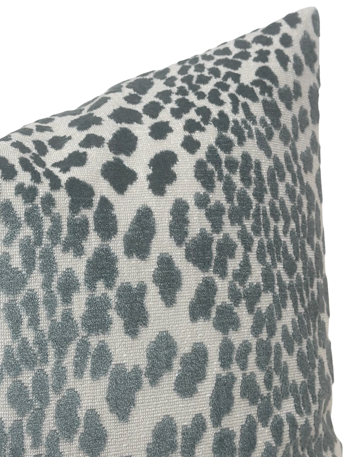 Close-up of a pillow cover featuring a spotted velvet pattern in shades of marine blue on a light grey background with a textured fabric surface.