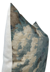Rectangular pillow with a textured fabric cover featuring an abstract woodland pattern in spa blue and earthy brown tones, shown at a three-quarter side angle.