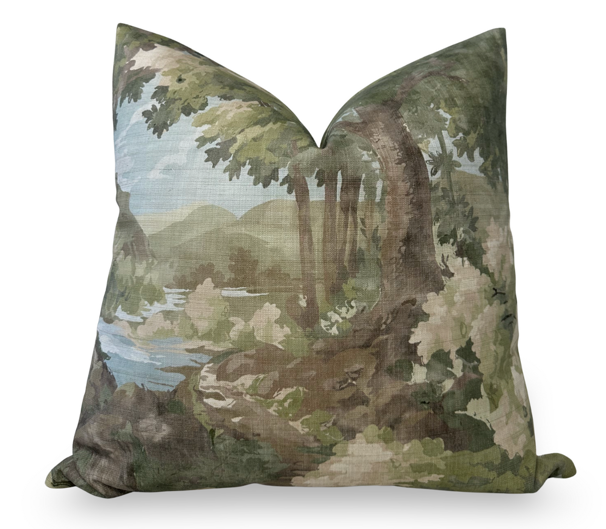 Square pillow with a printed design of a woodland scene featuring green foliage, tree trunks, and a distant body of water under a pale blue sky.