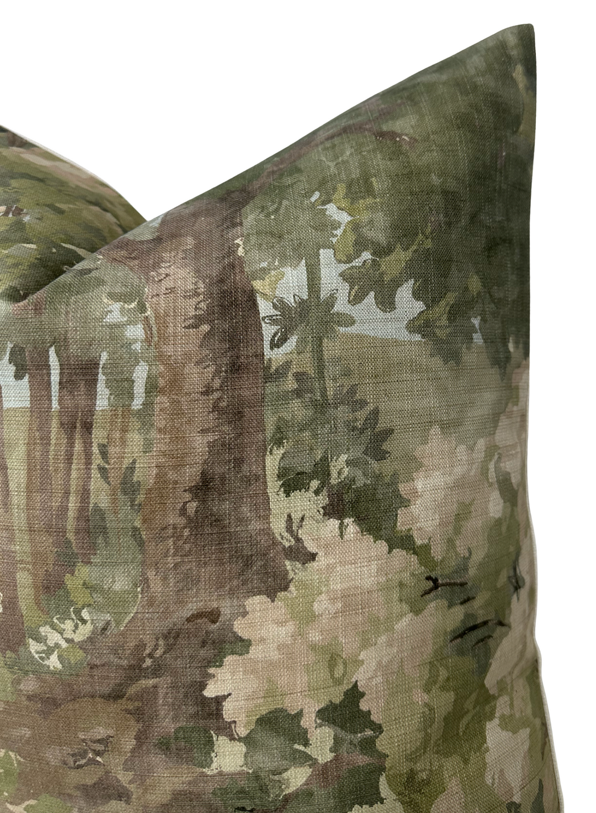 Close-up of a pillow cover with a green woodland pattern featuring trees, leaves, and white flowers in soft, muted watercolor tones.