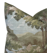 Decorative pillow cover with a woodland scene featuring green and brown tree leaves framing a distant hill and sky with water reflections.