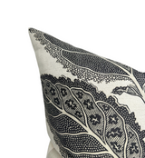 Beige pillow with large, intricate black leaf patterns featuring dotted and star-like designs on a fabric cover