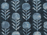 Indigo blue textile patterned with vertical rows of stylized light blue zinnia flowers and leaves on a textured dark indigo background.