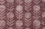Berry-colored fabric with a repeating pattern of stylized zinnia flowers featuring circular blooms and vertical leaf stems in lighter pink hues.