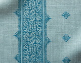 Teal blue Fez pillow cover fabric with a vertical central decorative band featuring intricate floral motifs and small diamond-shaped patterns on a textured light background.