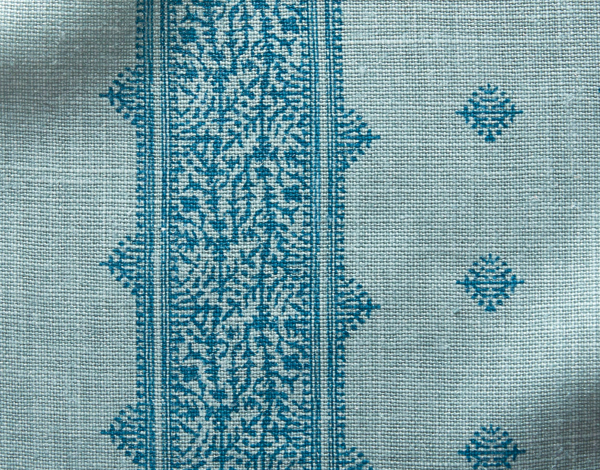 Teal blue Fez pillow cover fabric with a vertical central decorative band featuring intricate floral motifs and small diamond-shaped patterns on a textured light background.