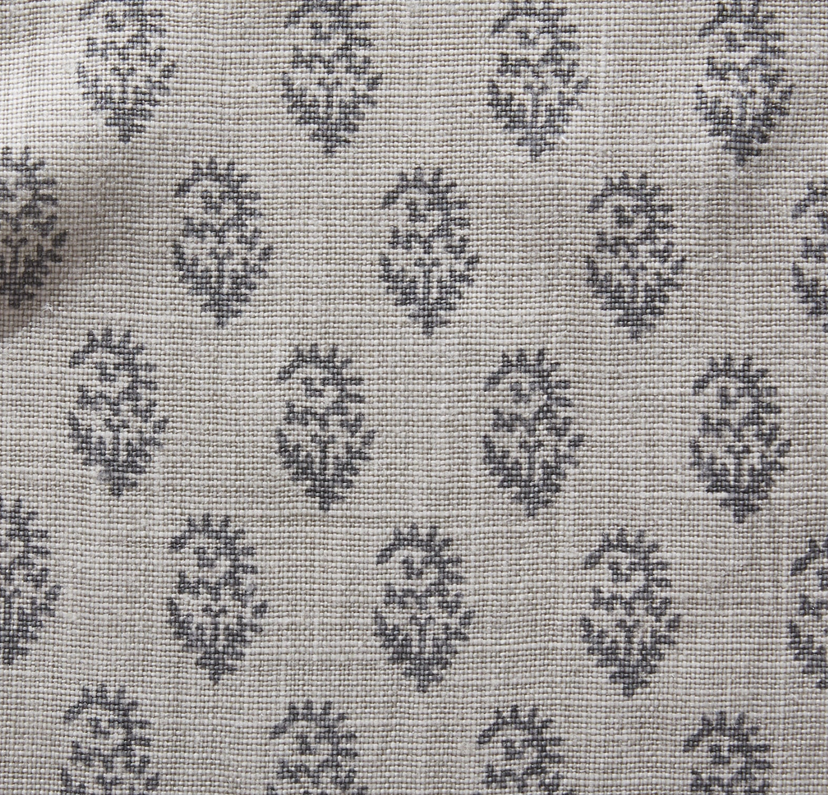 Ash grey textile with a repeating small floral motif pattern in dark grey, showing woven texture details of the fabric.
