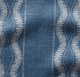 Close-up of indigo blue fabric with vertical white wavy and linear patterns, showing textured woven threads in a linen-like material.