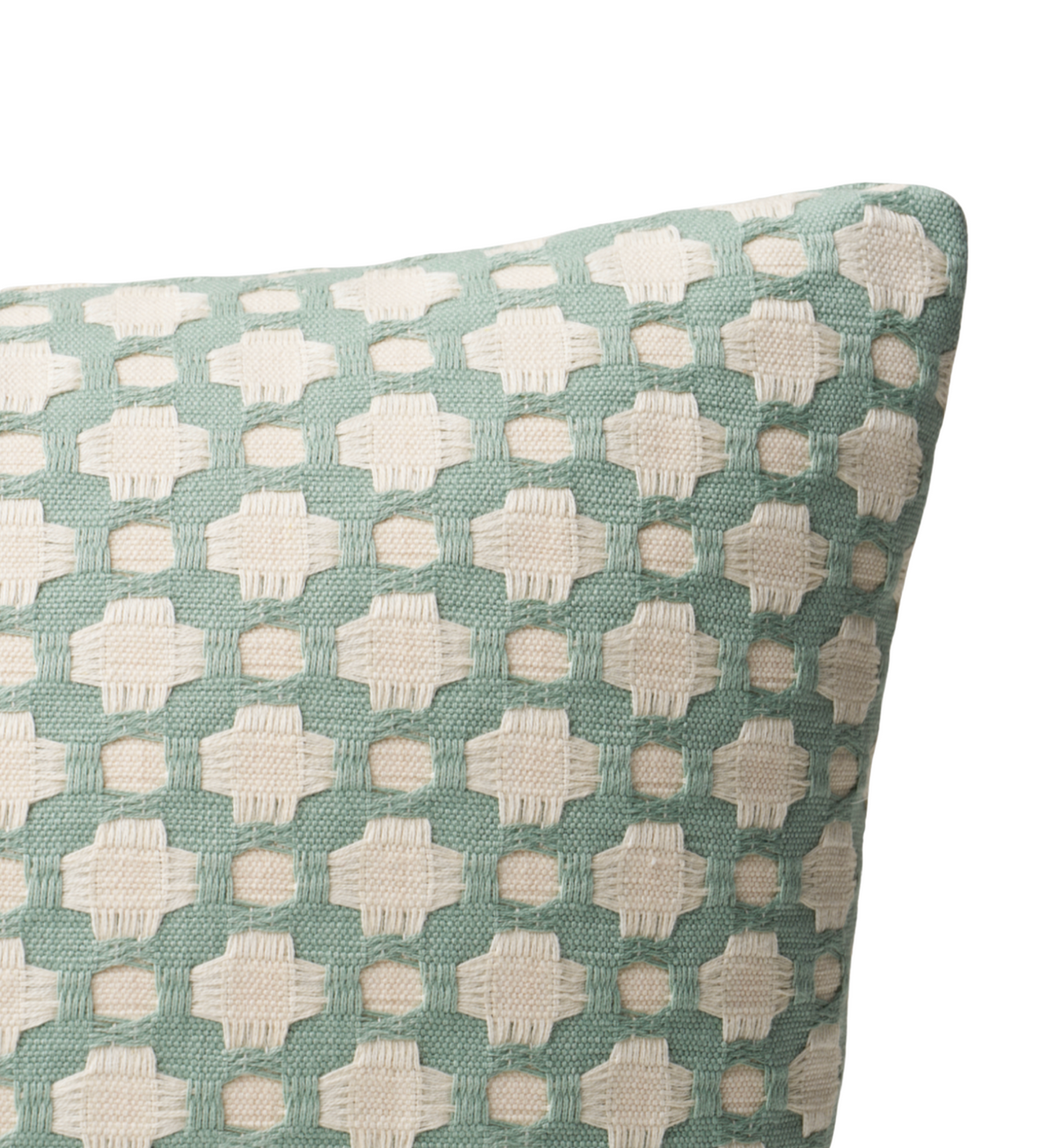 Close-up of a pillow cover with a woven geometric pattern of cream shapes on a soft green background, highlighting textured fabric detail.