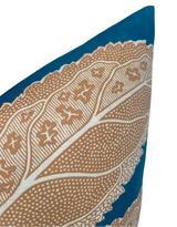 Corner of a pillow with a detailed beige floral pattern on a deep blue background, showcasing intricate dot and line designs.