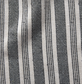 Fabric close-up showing alternating wide and narrow charcoal and natural-colored vertical stripes with a textured woven pattern.