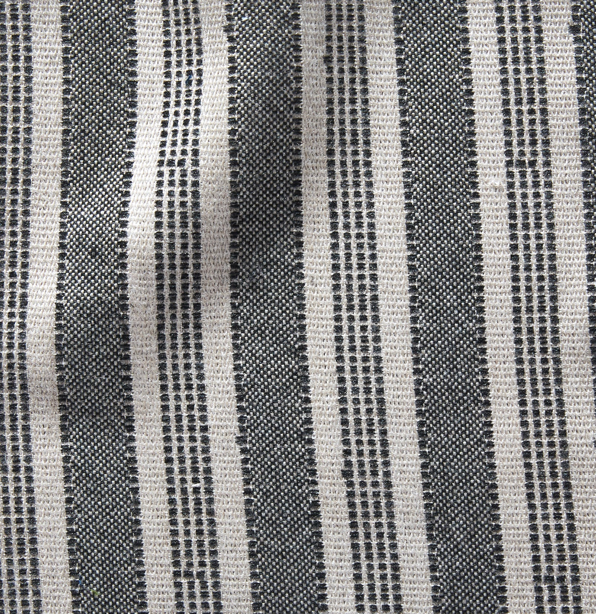 Fabric close-up showing alternating wide and narrow charcoal and natural-colored vertical stripes with a textured woven pattern.