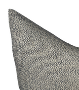 Close-up of a charcoal-colored woven pillow cover with a nubby textured fabric in a pointed corner view.