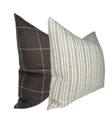 Two decorative pillows shown at an angle, one with beige and white vertical stripes and the other with dark brown and light beige windowpane pattern.