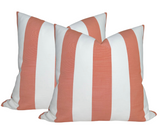 Two square pillows with wide vertical stripes in melon peach and white, arranged side by side on a white background.