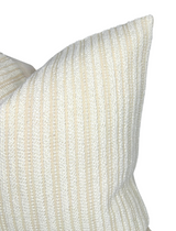 Close-up of a woven pillow cover in ecru with subtle vertical stripes in cream and beige, showing detailed texture and soft fabric folds.