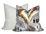 Two decorative pillow covers, one with a subtle taupe floral pattern on a light background, the other with a bold abstract pattern in taupe, gray, and rust tones.