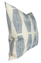 Cream-colored pillow with a repeated geometric inlay pattern in lake blue, featuring intricate circular and linear details in vertical rows.
