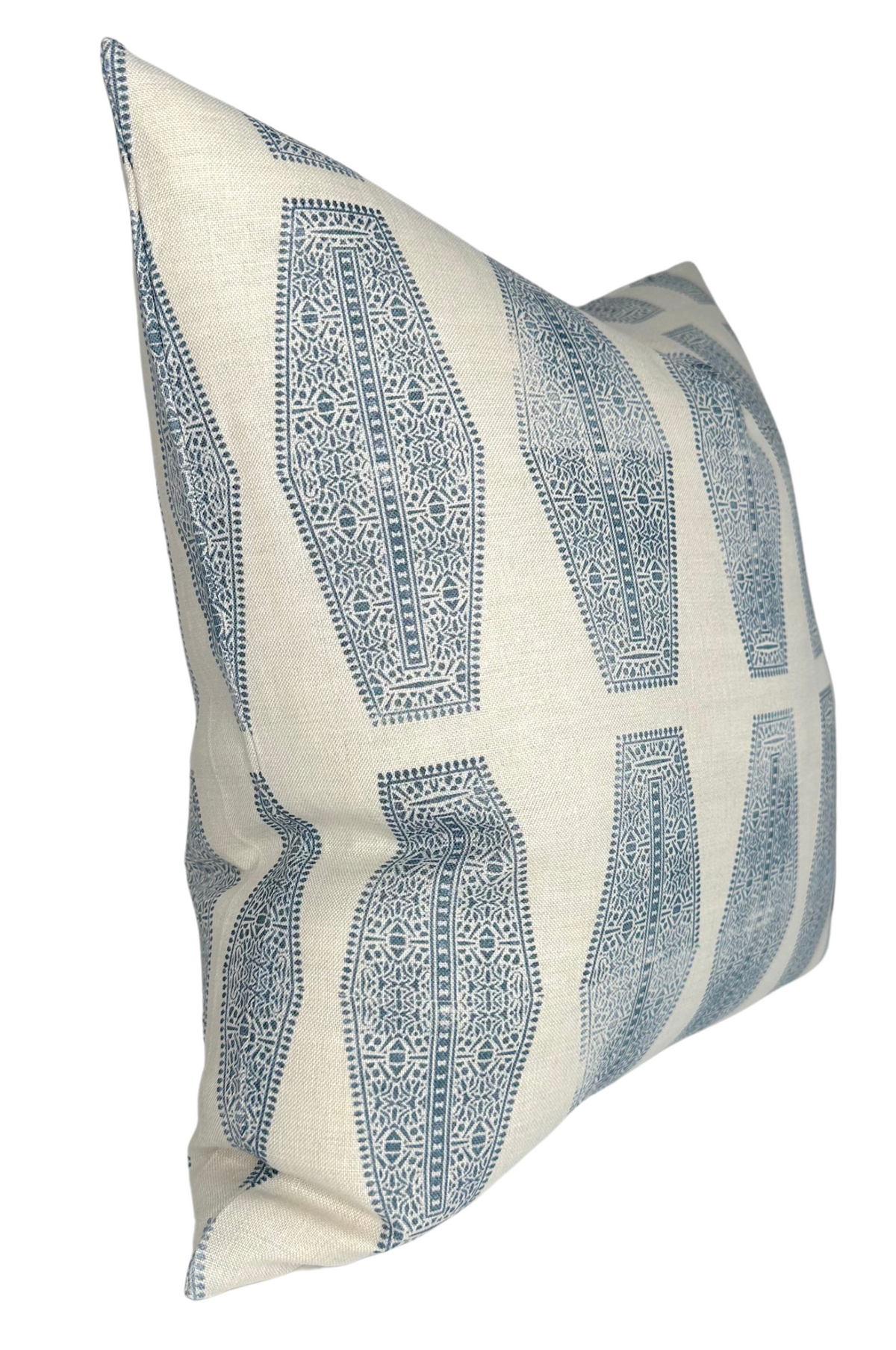 Cream-colored pillow with a repeated geometric inlay pattern in lake blue, featuring intricate circular and linear details in vertical rows.