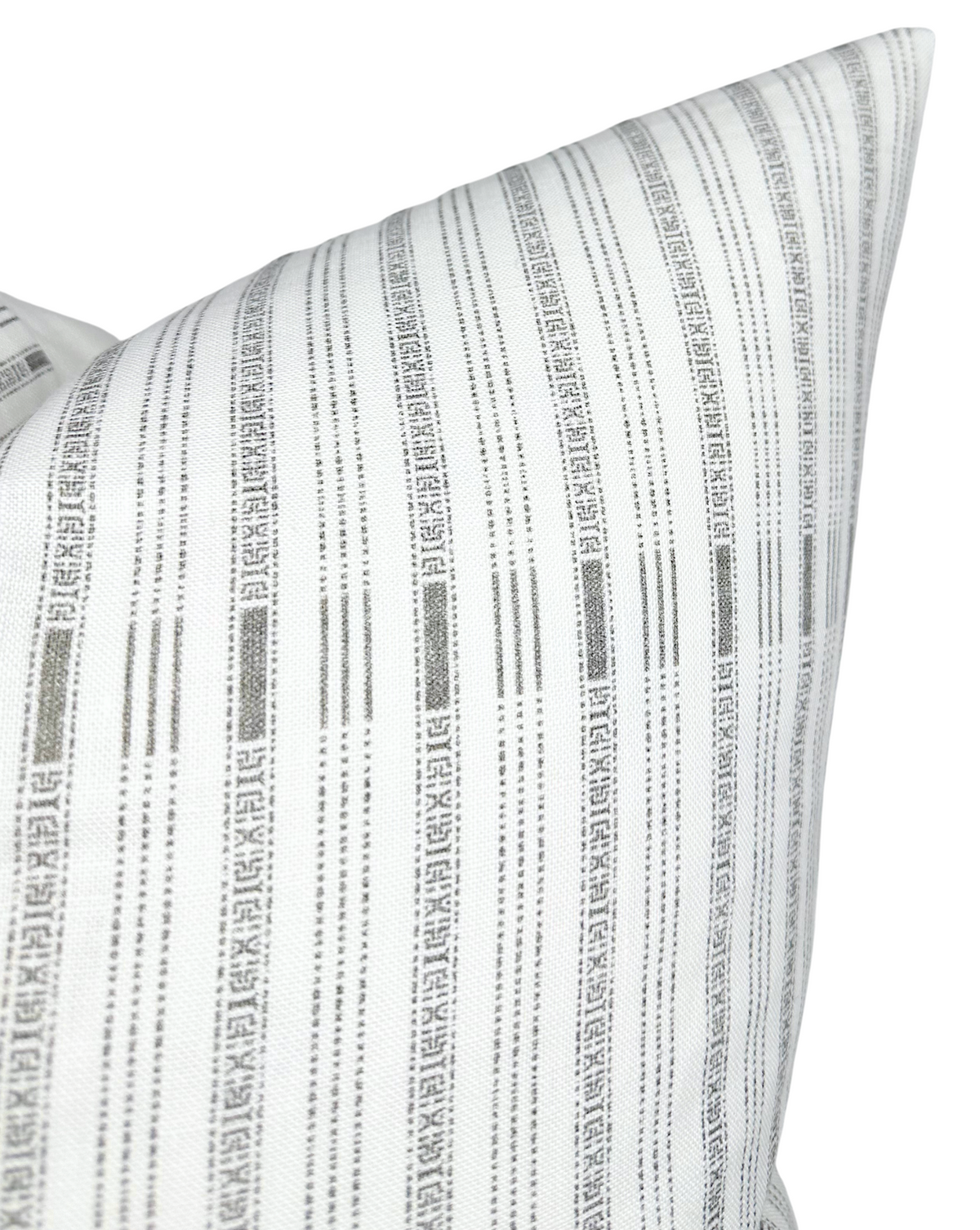 White pillow cover with vertical charcoal gray stripes featuring intricate geometric patterns, shown at a close angle highlighting texture and sharp corners.