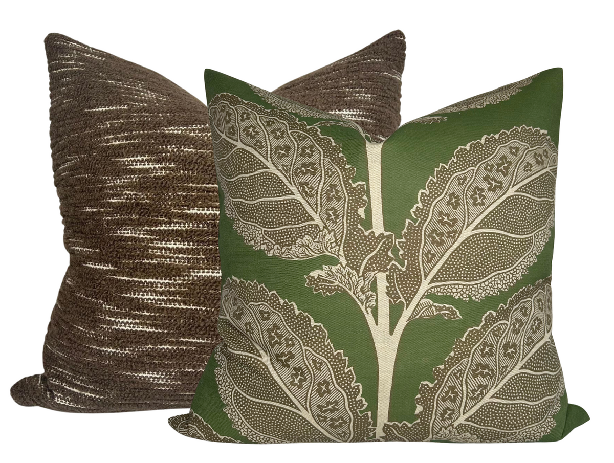 Two square pillow covers, one with a textured brown weave and the other in green with a large, intricate beige leaf pattern, displayed side by side.