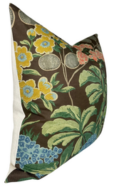 Square pillow with brown background featuring large floral pattern in yellow, blue, green, and coral, with white sides and a textured fabric appearance.