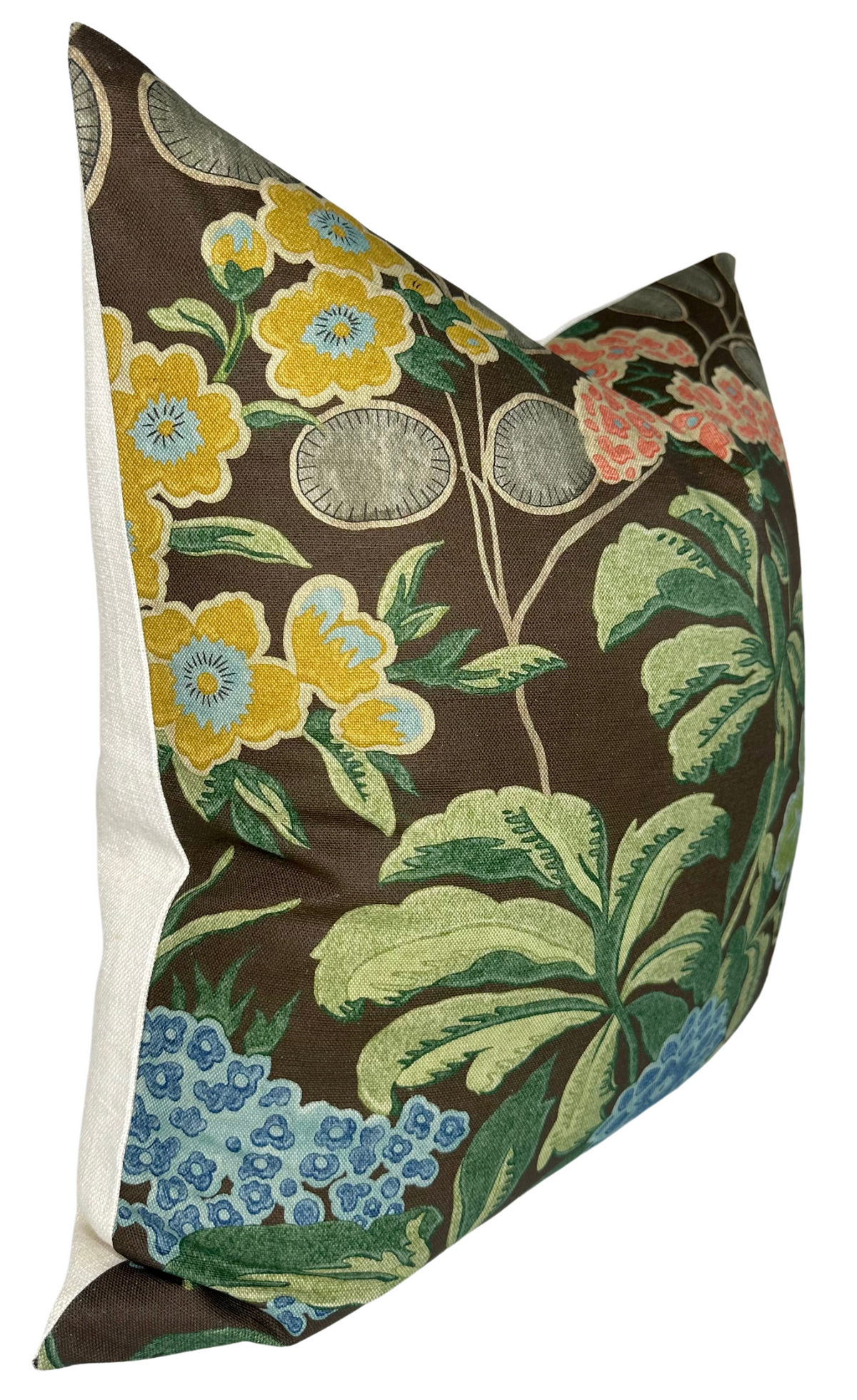 Square pillow with brown background featuring large floral pattern in yellow, blue, green, and coral, with white sides and a textured fabric appearance.