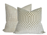 Two square pillows with textured fabric; front pillow features a geometric maze pattern in shades of greige, while the back pillow has a subtle woven texture in a soft neutral tone.